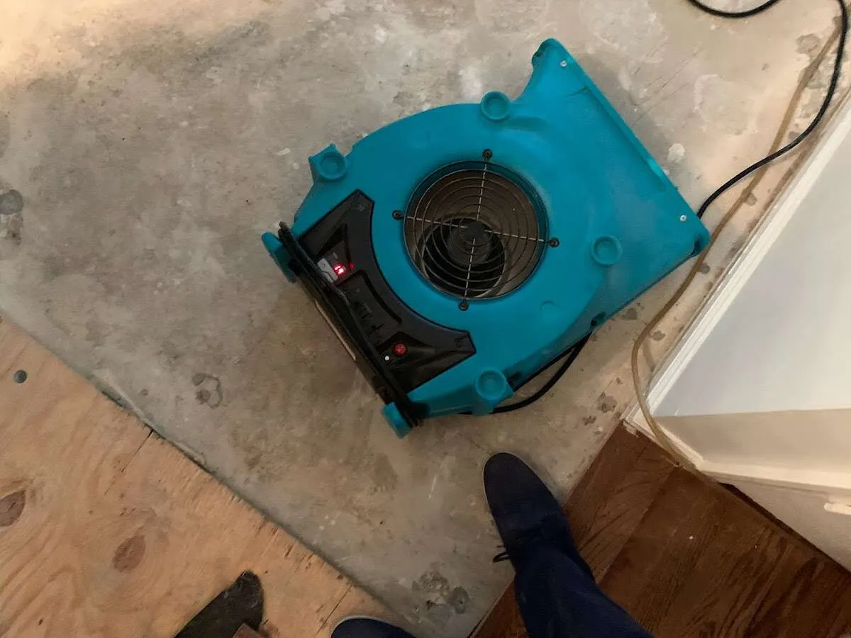 Air mover drying subfloor during Commercial Water Damage Restoration in Hapeville